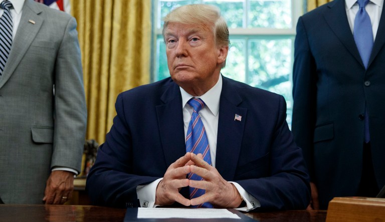 President Trump sits at the Resolute Desk in the White House.