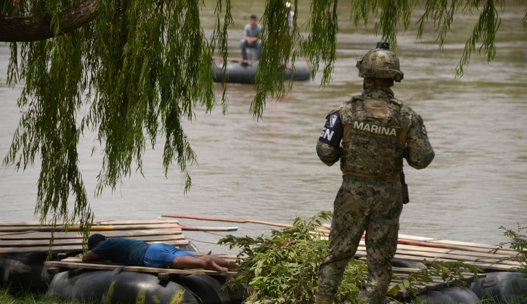 A Mexican National Guard (GN) stands on the bank of the Suchiate River where porters on rafts work between Guatemala and Mexico, during a press tour organized by the GN to show their work near Ciudad Hidalgo, Mexico.