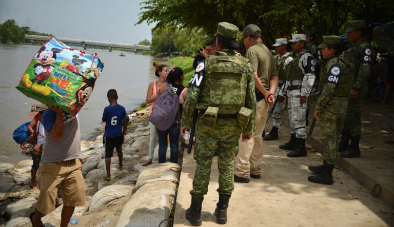 Mexican migration officials check the identification cards of people crossing the Suchiate River where Mexican National Guards stand guard near Ciudad Hidalgo, Mexico, Wednesday, July 3, 2019.