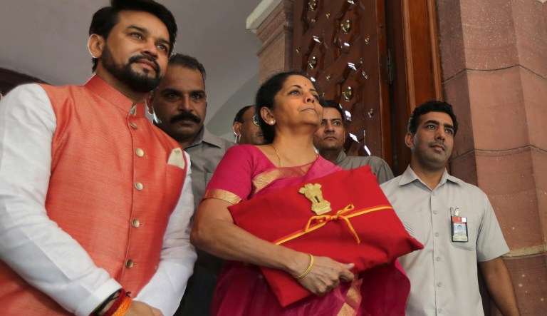 Indian Finance Minister Nirmala Sitharaman, center, and junior Finance Minister Anurag Thakur, left, stands for the media at the parliament house before presenting the annual federal budget in New Delhi, India, on Friday.