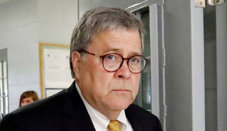 Attorney General William Barr leaves a building.