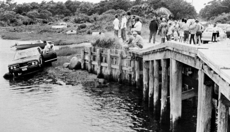 In this July 19, 1969 photograph, crowds watch as U.S. Sen. Edward Kennedy's car is pulled from water at the Dyke Bridge in Edgartown, Mass. It's been 50 years since the fateful automobile accident that killed a woman and thwarted Kennedy's presidential aspirations.