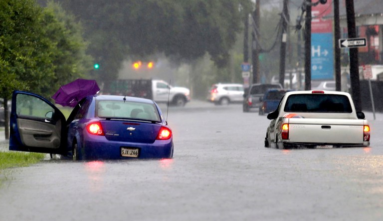 Vehicles are stuck in floodwaters along S. Galvez Street as heavy rain falls in New Orleans. 