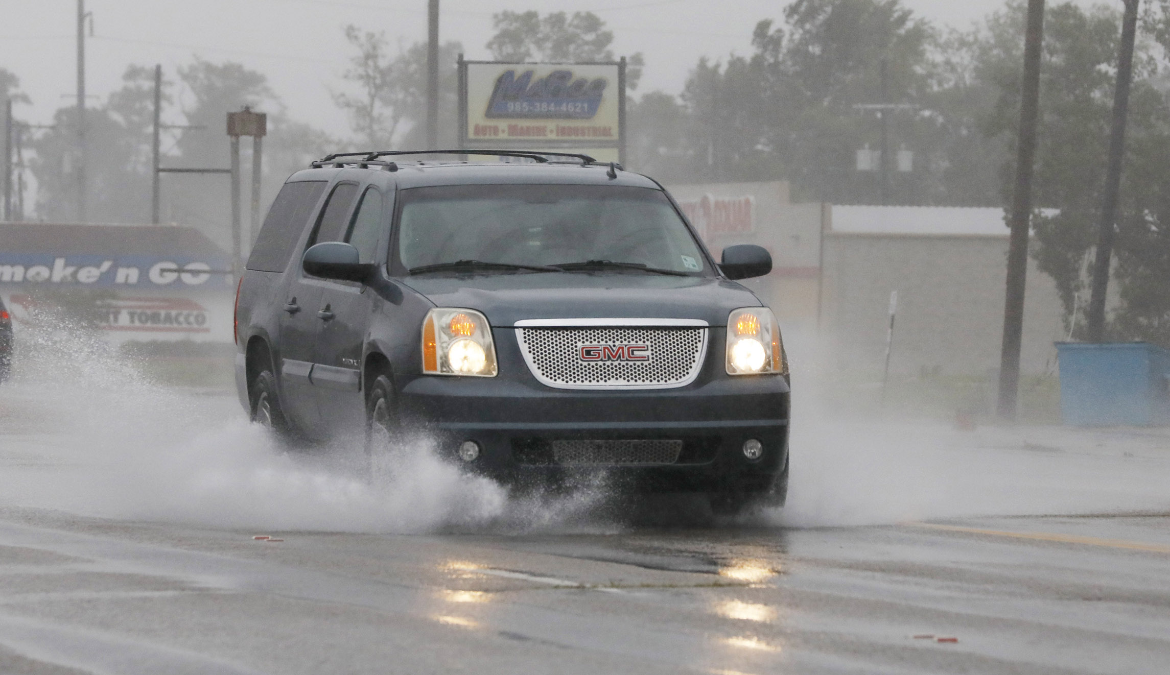 A vehicle kicks up a water spray as winds and rain increase in Morgan City, Louisiana, Saturday morning as Barry approaches.