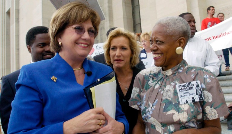 In this April 20, 2004 photo, Rep. Carla Blanchard Dartez, D-Morgan City, center covers Gov. Kathleen Blanco, left, as a few drops of rain fall while talking with Sadie Roberts-Joseph, right, before the start of the Stand Up for Children 2004 Rally for Children on the steps of the State Capitol in Baton Rouge, La. 