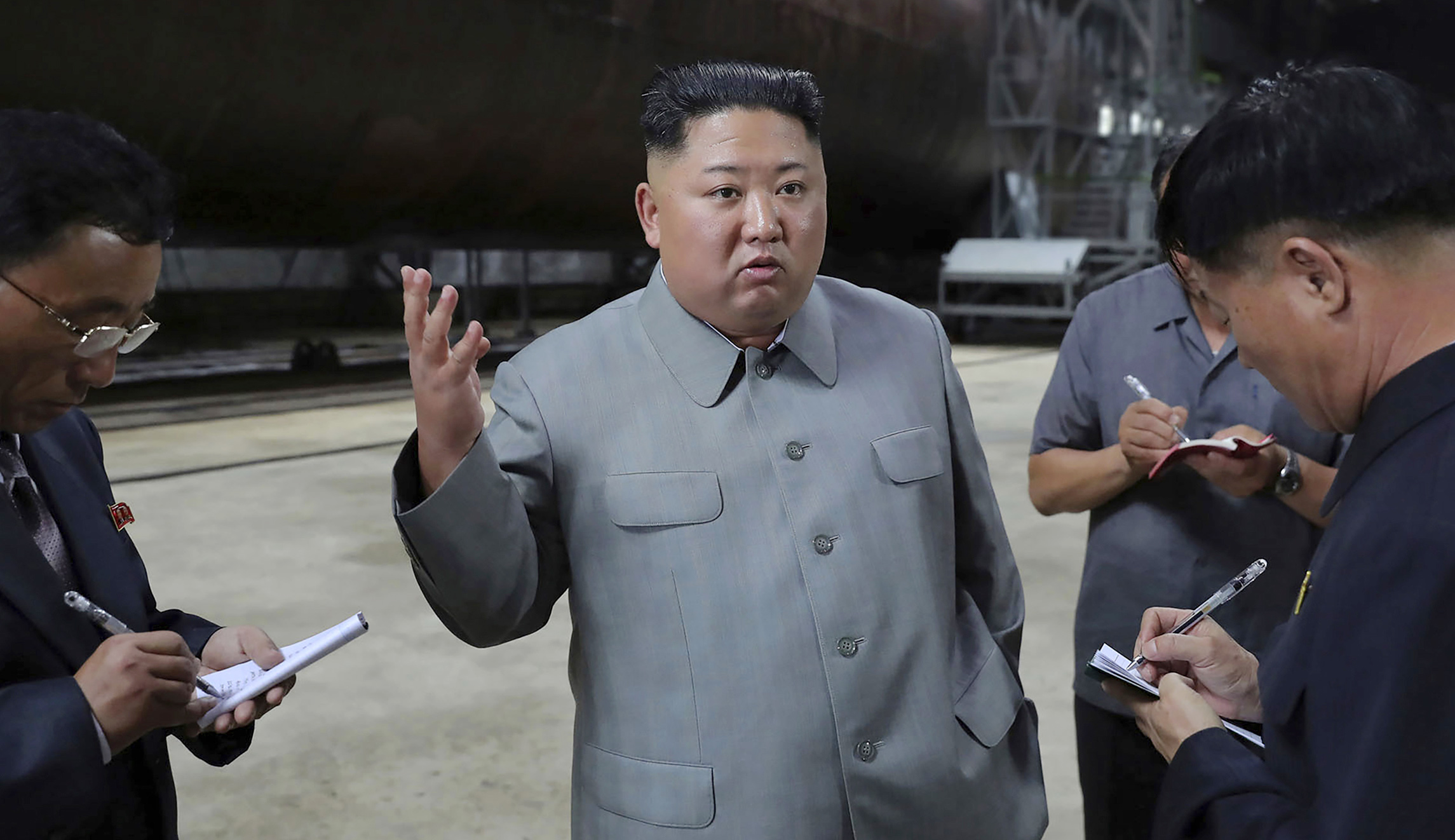 In this undated photo provided on Tuesday by the North Korean government, North Korean leader Kim Jong Un, center, speaks to a small group.