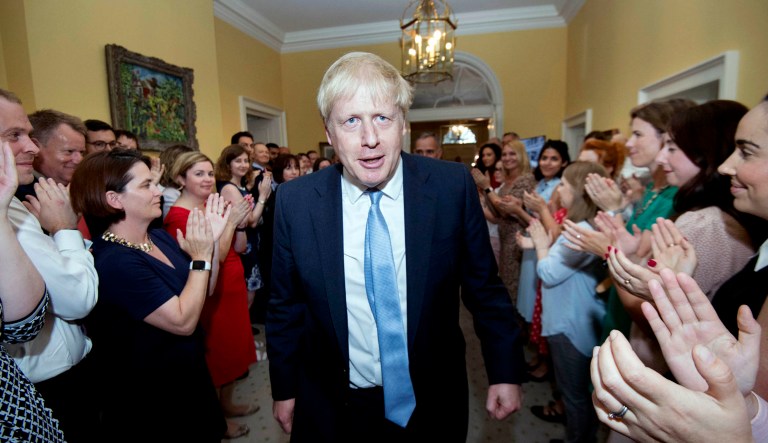 Britain's new Prime Minister Boris Johnson is welcomed into 10 Downing Street by staff, in London.