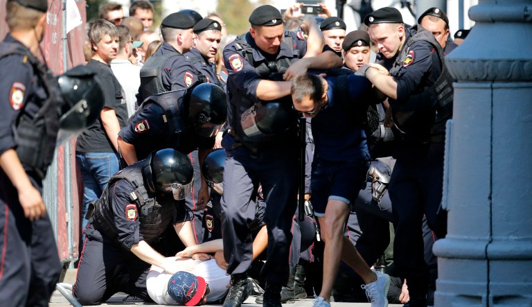 Police officers detain people during an unsanctioned rally in the center of Moscow, Russia, on Saturday. Russian police are wrestling with demonstrators and have arrested hundreds in central Moscow during a protest demanding that opposition candidates be allowed to run for the Moscow city council.