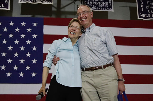 Democratic presidential candidate Sen. Elizabeth Warren, D-Mass., hugs her husband, Bruce Mann, before speaking at a campaign event, Saturday, July 27, 2019, in Derry, N.H.