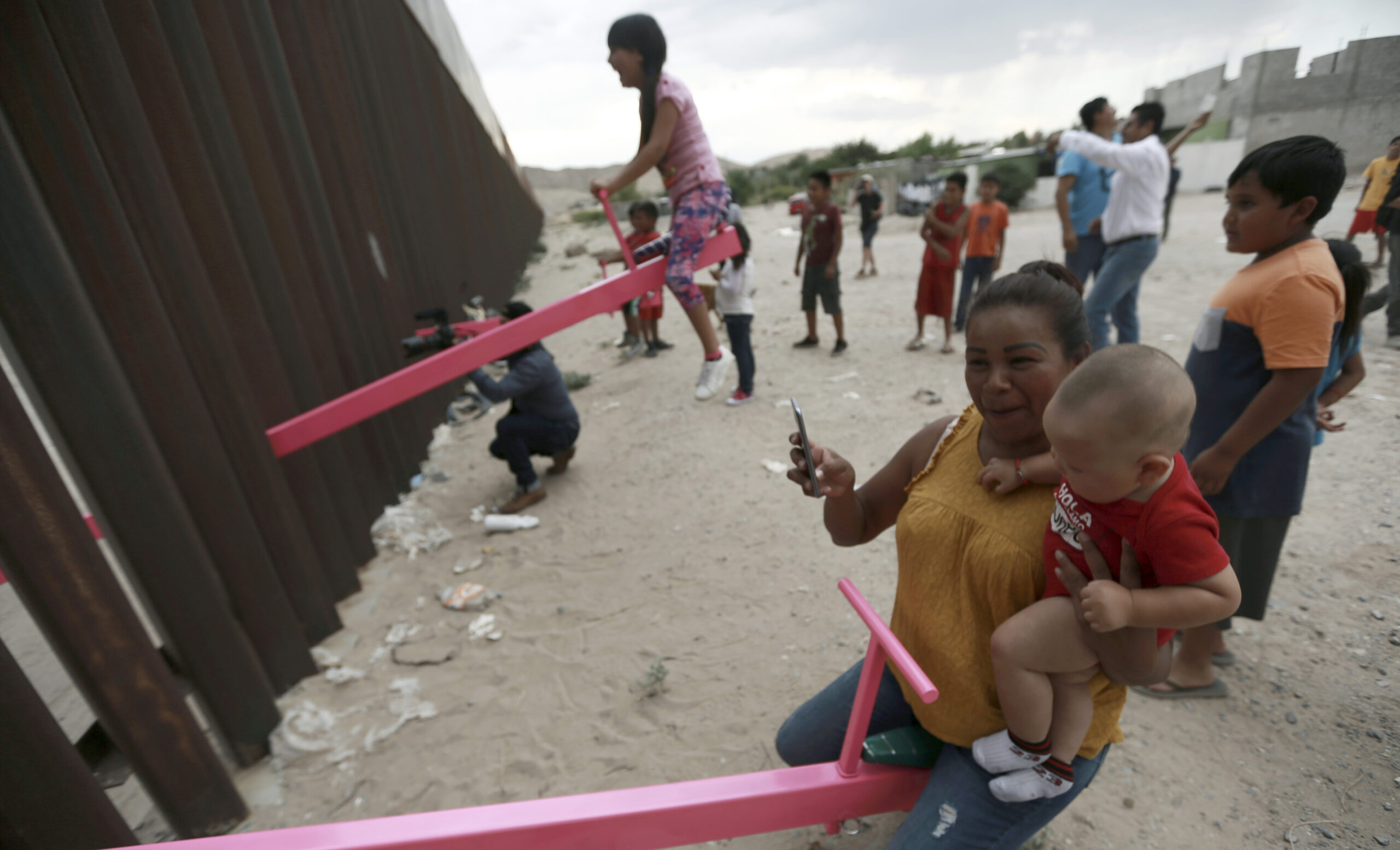 Seesaws create cross-nation playtime for children at US southern border
