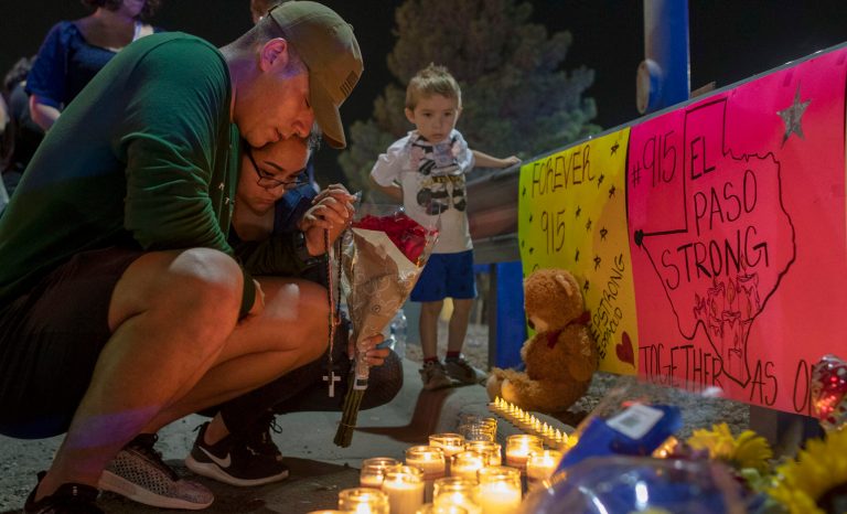Rene Aguilar and Jackie Flores pray at a makeshift memorial for the victims of Saturday's mass shooting at a shopping complex in El Paso, Texas, Sunday, Aug. 4, 2019. 