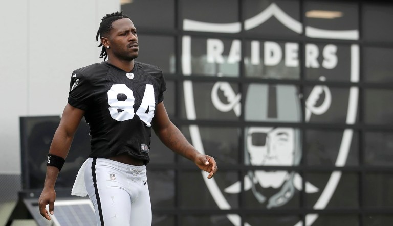Oakland Raiders' Antonio Brown walks on the field while stretching during NFL football practice in Alameda, California.