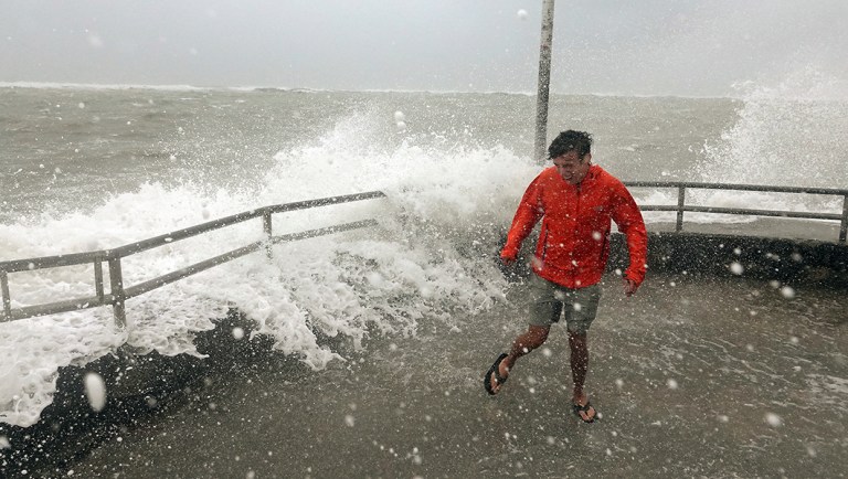 Brandon Ennis runs away from waves caused by Hurricane Dorian.