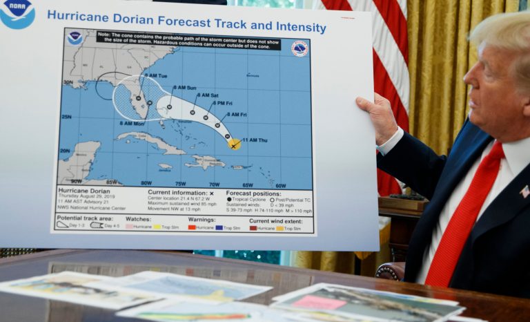 President Donald Trump holds a chart as he talks with reporters after receiving a briefing on Hurricane Dorian in the Oval Office of the White House, Wednesday, Sept. 4, 2019, in Washington. 
