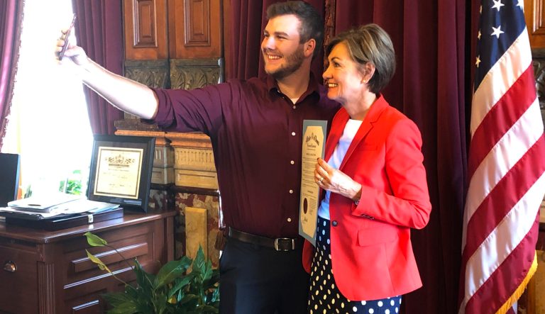 Carson King, of Altoona, Iowa, snaps a selfie Wednesday, Sept. 25, 2019, in the Iowa State Capitol in Des Moines, Iowa, with Iowa Gov. Kim Reynolds, who holds a proclamation declaring Saturday as Carson King Day. 