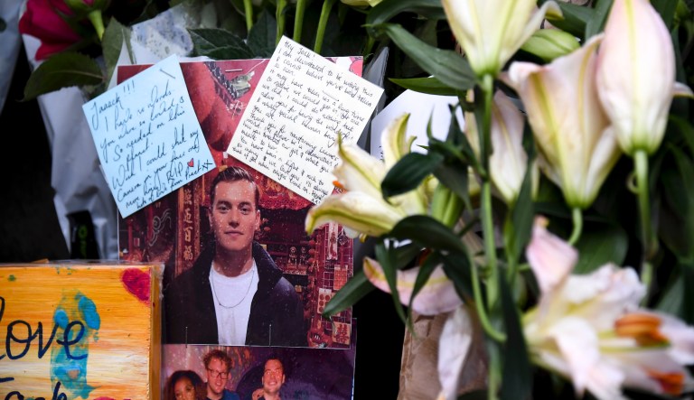 Flowers and a pictures are left in memory of Jack Merritt who has been named as the first victim of Friday's terror attack on London Bridge in London, Sunday, Dec. 1, 2019. 