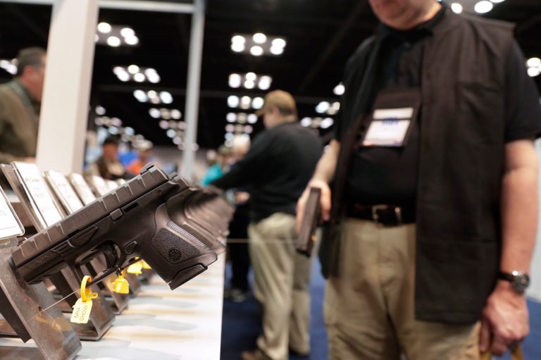 A gun enthusiast looks over the display of pistols in the exhibition hall at the National Rifle Association annual meeting in Indianapolis this year. Eight states have joined the movement to create gun "sanctuaries" against gun control laws.