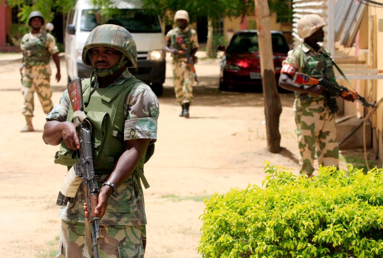In this 2013 file photo, Nigerian soldiers stand guard at the offices of the state-run Nigerian Television Authority in Maiduguri, Nigeria.