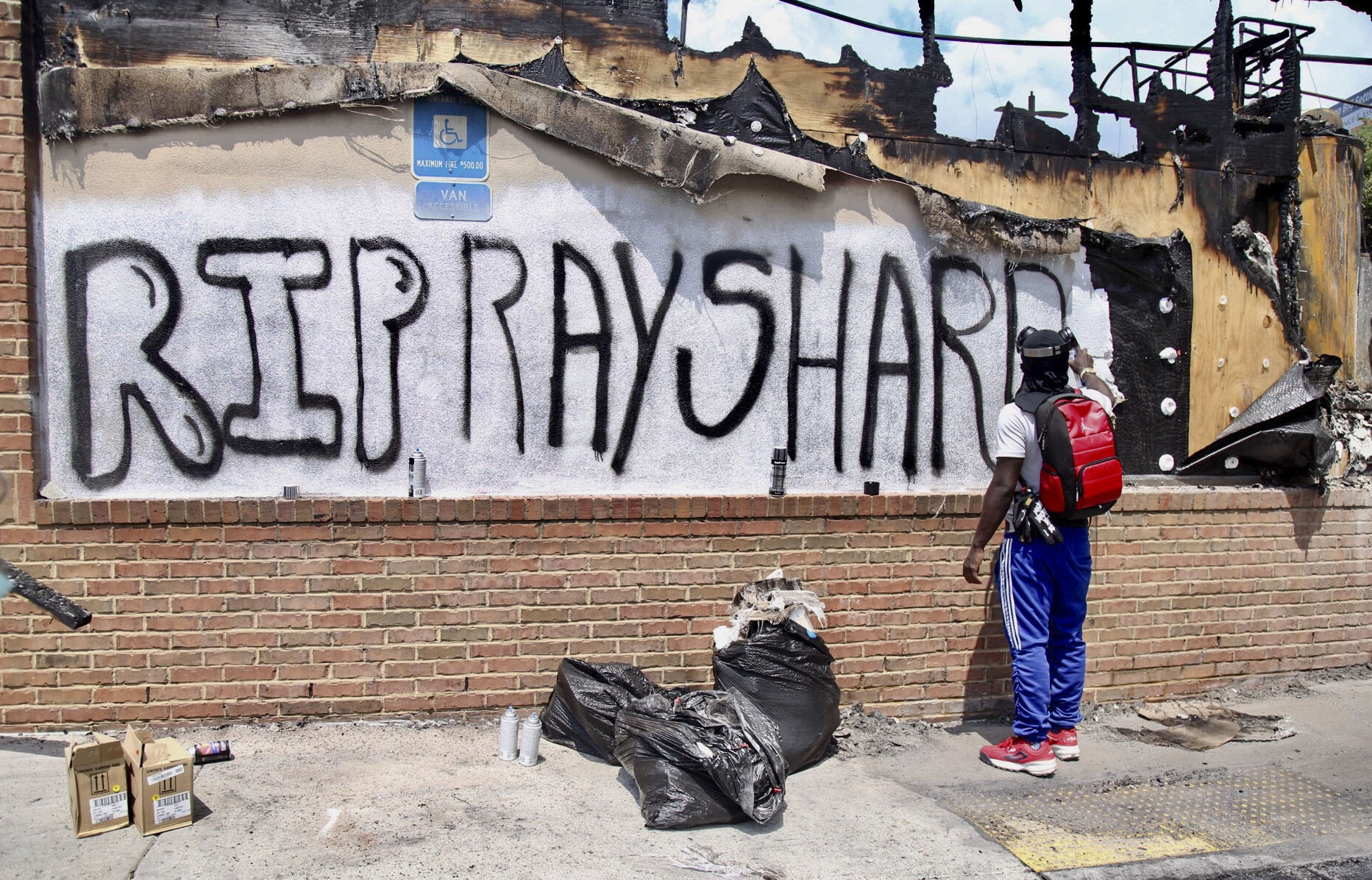 Three armed men tell reporter they are keeping police out of area where Rayshard Brooks died