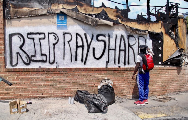Three armed men tell reporter they are keeping police out of area where Rayshard Brooks died