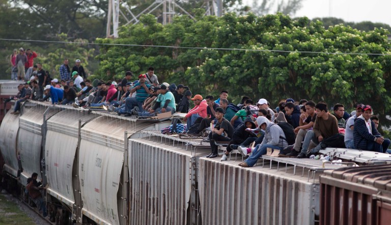 Central American migrants climb off a freight train during their journey toward the U.S.-Mexico border.