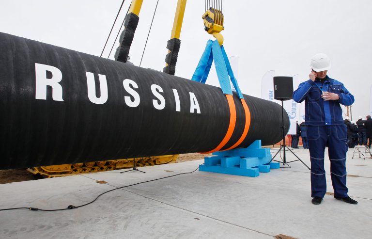 In this photo from a 2010 ceremony marking the beginning of natural gas pipeline construction in Portovaya Bay, Russia, a construction worker speaks on a cellphone.