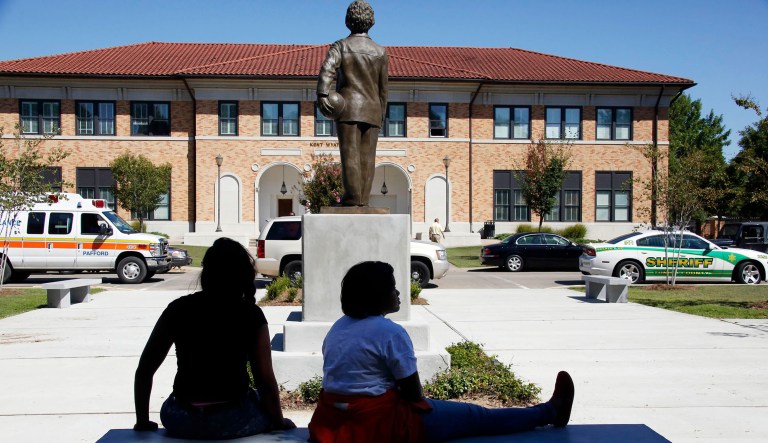 Students sit on a bench in front of Kent Wyatt Hall on Delta State University's Cleveland, Mississippi, campus.