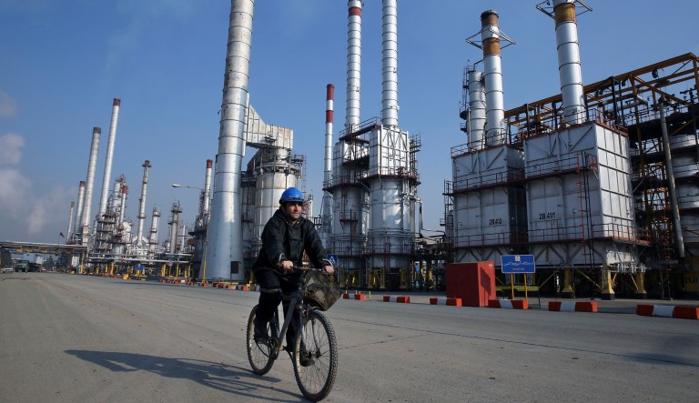 FILE - In this Dec. 22, 2014 file photo, an Iranian oil worker rides his bicycle at the Tehran oil refinery, south of the capital Tehran, Iran. State-run Press TV quoted the Iranian Oil Minister Bijan Namdar Zangeneh on Sunday, March 13, 2016, saying that U.S. companies are welcome to invest in Iran's oil and gas industry. The TV report said Zangeneh also asked the German company Siemens executives to invest in Iran's oil and gas industry. 