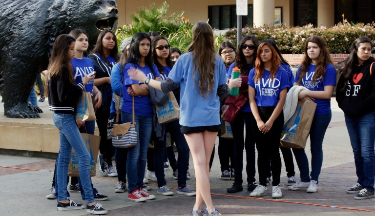 FILE - In this Feb. 26, 2015 file photo, UCLA campus tour guide Samantha St. Germain, a bioengineering student, middle, leads prospective college-bound high school seniors on a campus tour in Los Angeles. Fewer California high school students have been offered admission to University of California campuses for the fall, officials reported Thursday, July 2, 2015, while the number accepted from outside the state and abroad has again increased.