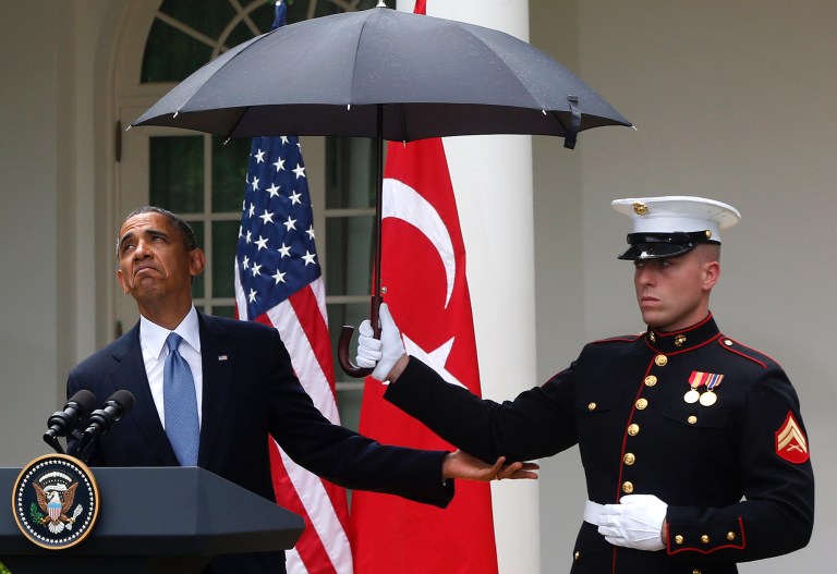 President Barack Obama speaks under an umbrella held by a Marine as a light rain falls during a news conference with Turkish Prime Minister Recep Tayyip Erdogan, Thursday, May 16, 2013, in the Rose Garden of the White House.