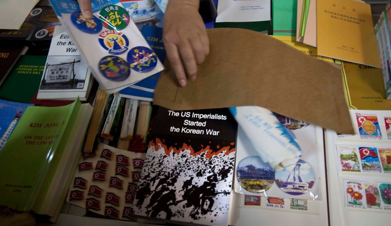A North Korean woman sells souvenirs, including a book titled The US Imperialists Started The Korean War, in Pyongyang. 