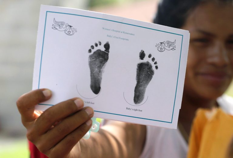 In this Wednesday, Sept. 16, 2015 photo in Sullivan City, Texas, a woman who is in the country illegally shows the footprints of her daughter who was born in the in the United States.