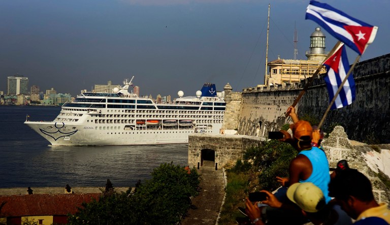 In this May 2, 2016 photo, people waving Cuban flags greet passengers on Carnival's Adonia cruise ship as they arrive from Miami in Havana, Cuba.