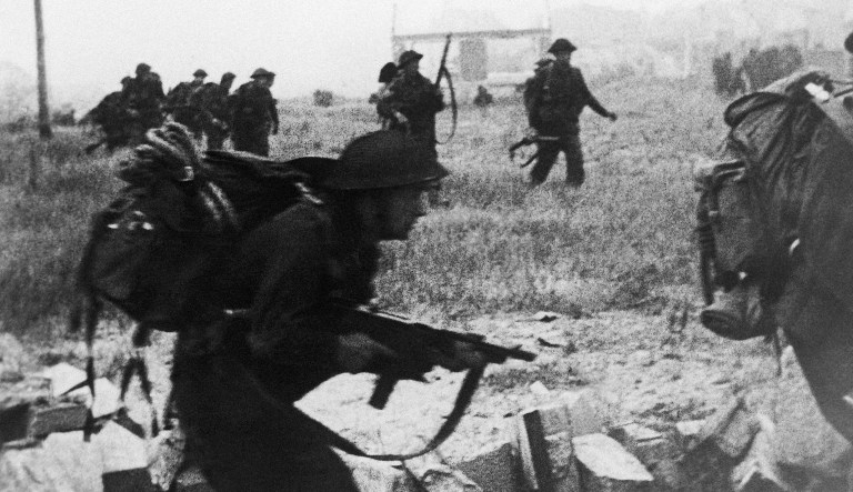 British Commando troops landing on the Normandy beachhead on D-day. British Commandos advancing inland to gain the first Normandy village, on June 7,1944.