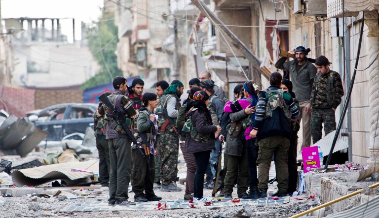 Fighters from Kurdish popular defense units YPJ (women) and YPG  men) gather during a short break before heading out to fight for new positions in Kobani, Syria.
