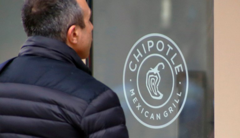 Vladimir Faingold reads a sign on the door of a Chipotle restaurant in Pittsburgh's Market Square.