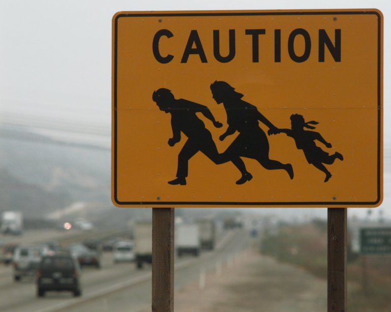 Asign warns motorists of the possibility of undocumented immigrants crossing the freeway near the border in San Diego.