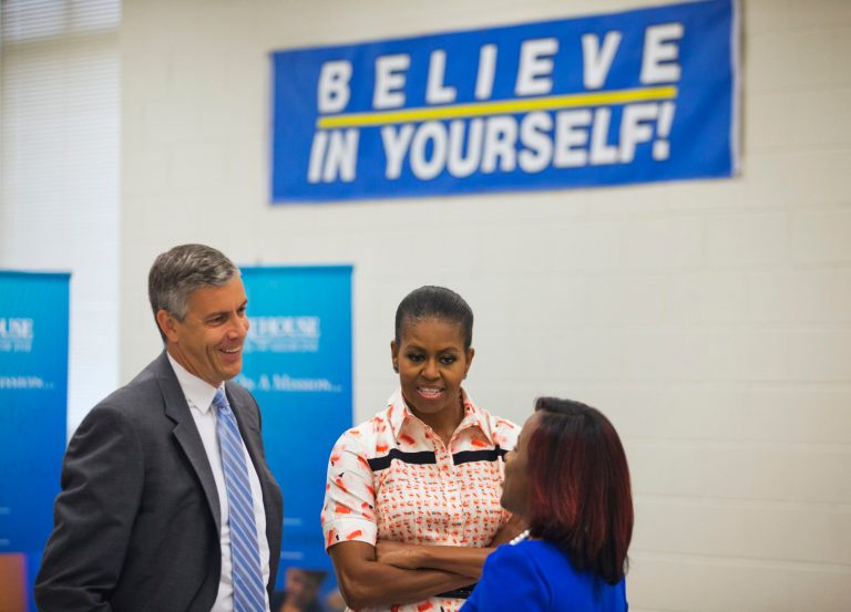 U.S. Secretary of Education Arne Duncan, left, and First Lady Michelle Obama, center, greet former Booker T. Washington High School and current Kennesaw State University student Alexandria Jones, as they tour a college fair at the high school as part of her Reach Higher educational initiative, Monday, Sept. 8, 2014, in Atlanta.