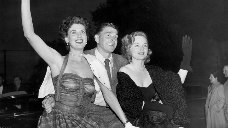 Ronald Reagan, center, and actresses Lucille Barkley, left, and Wanda Hendrix wave to the crowd at the railroad station in Pasadena, Ca., after the 15-mile trip from Los Angeles, Ca., on the junket for the premiere of a movie on June 23, 1950. The Hollywood party drove down Pasadena's main street for the film opening in the Pasadena Civic Auditorium. 