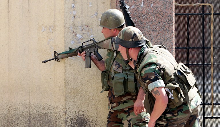 Lebanese army soldiers take their position behind a church wall during clashes in Tripoli, Lebanon.