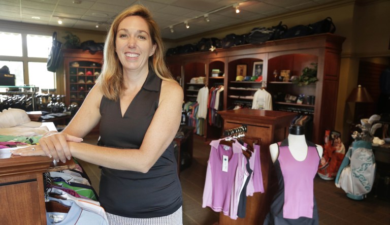 Kelly Daugherty, co-owner of Smashing Golf & Tennis, poses for a photo with her clothing line in the pro shop at Biltmore Country Club in North Barrington, Ill. 