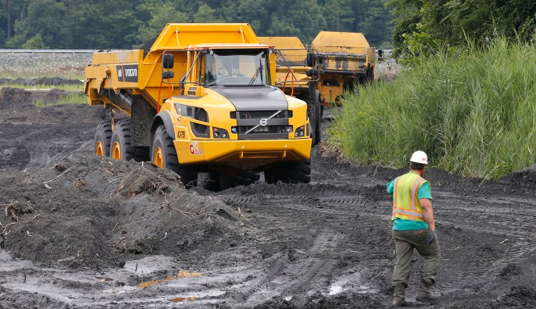 Trucks haul coal ash from one retention pond to a permanent pond at the Dominion Power's Possum Point Power Station  in Dumfries, Va., Friday, June 26, 2015.  The company is moving coal ash from several ponds to one lined pond.