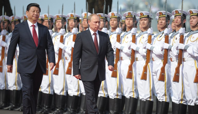 Russia's President Vladimir Putin, centre, and China's President Xi Jinping left, walk to open joint naval exercises in Shanghai, China, Tuesday, May 20, 2014.