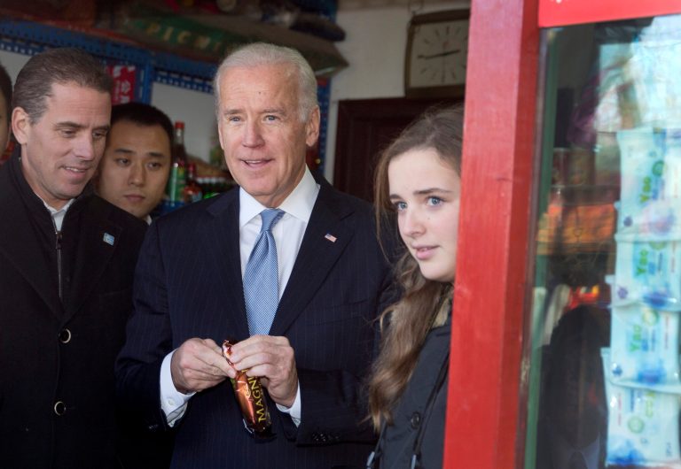 Former Vice President Joe Biden, center, buys an ice-cream at a shop as he tours a Hutong alley with his granddaughter Finnegan Biden, right, and son Hunter Biden, left, in Beijing, China Thursday, Dec. 5, 2013.