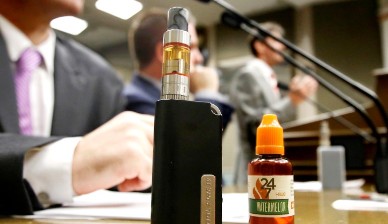 An e-cigarette and e-liquid are displayed during a hearing in California.