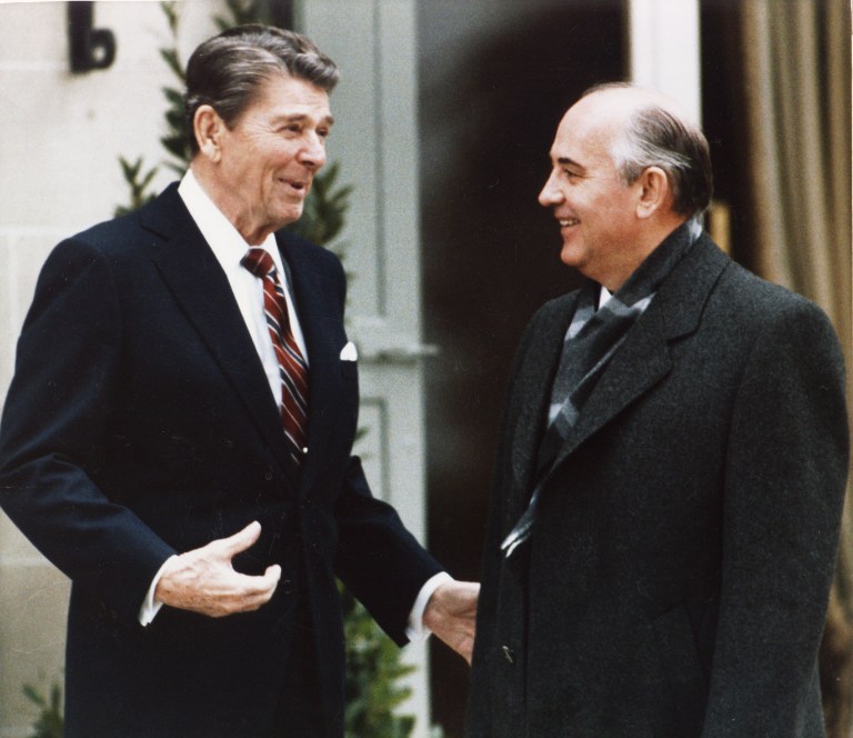 President Ronald Reagan in just a suit coat smiles as he talks to bundled up Soviet leader Mikhail Gorbachev outside the vila Fleur D'Eau at Versoix ner Geneva, on a chilly November Tuesday morning in 1985.