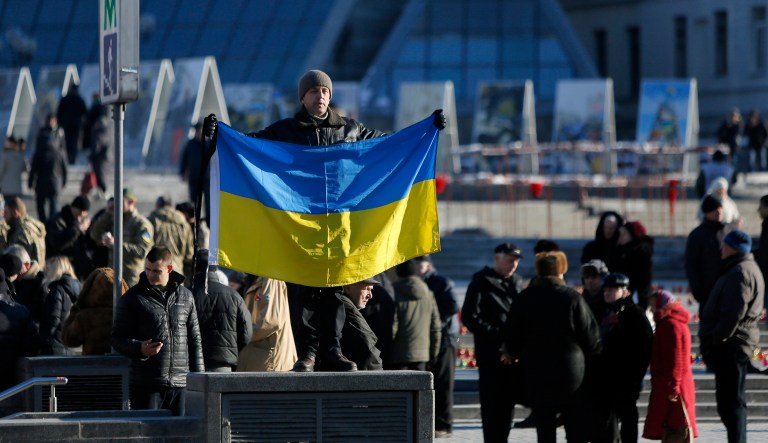 A man holds the Ukrainian national flag at Independence Square in Kiev, Ukraine, Wednesday, Feb. 18, 2015. Municipal workers are preparing the square to commemorate the Maidan protest movement and the events which took place in late Feb. 2014 that led to the departure of former Ukrainian President Victor Yanukovich and the formation of a new government.