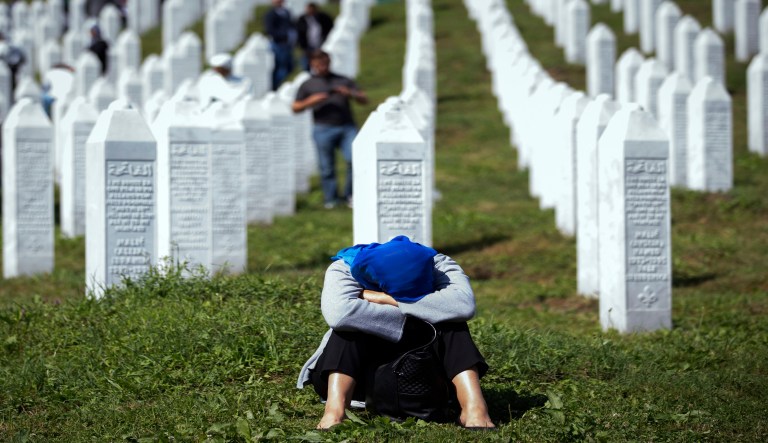 A woman rests at the memorial cemetery, prior to the funeral in Potocari, near Srebrenica, Bosnia, Thursday, July 11, 2019.