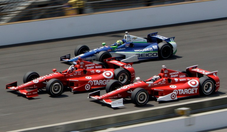 Dario Franchitti, center, of Scotland, leads teammate Scott Dixon, bottom, of New Zealand, and Tony Kanaan, top, of Brazil, to the finish line on the final lap of IndyCar's Indianapolis 500 auto race at Indianapolis Motor Speedway in Indianapolis, Sunday, May 27, 2012. 
