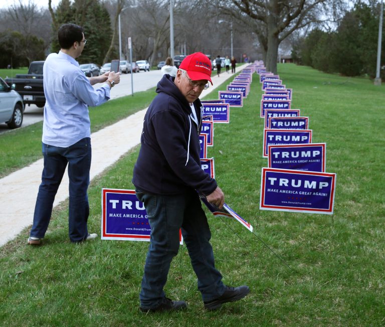 Volunteer Elam Stoltzfus, from Lancaster, Pa., places yard signs for Republican presidential candidate, Donald Trump, outside a rally Sunday, April 3, 2016, in West Allis, Wis. The party has heavily invested in its ground game.